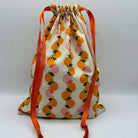 Drawstring bag with fruit pattern and orange drawstrings on a white background