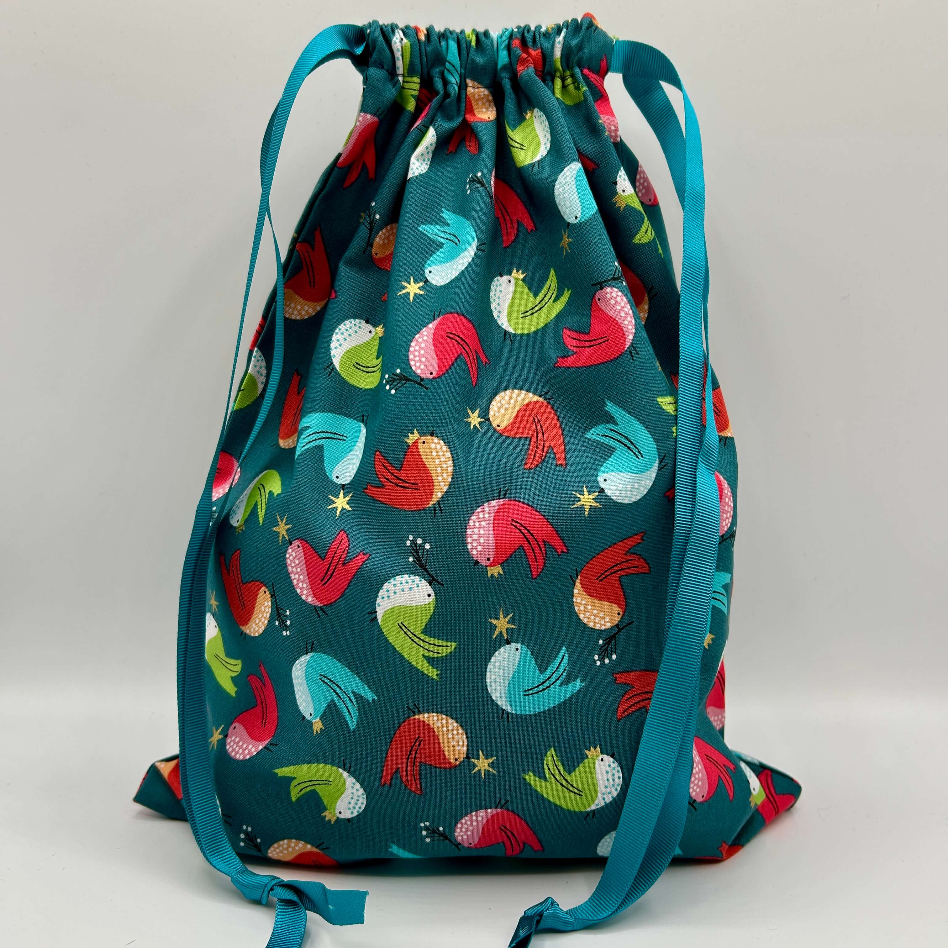 Drawstring bag with colorful bird pattern on a gray background